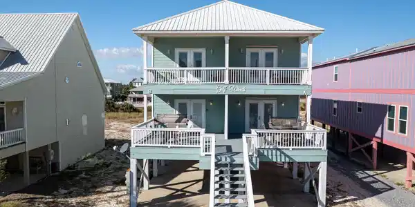 Image 4: Coastal inspired home featuring french doors, a carport, a metal roof, and concrete driveway