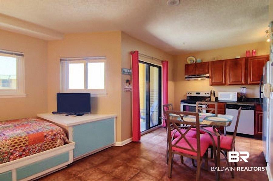 Image 3: Combined living and kitchen space featuring wood-finish flooring