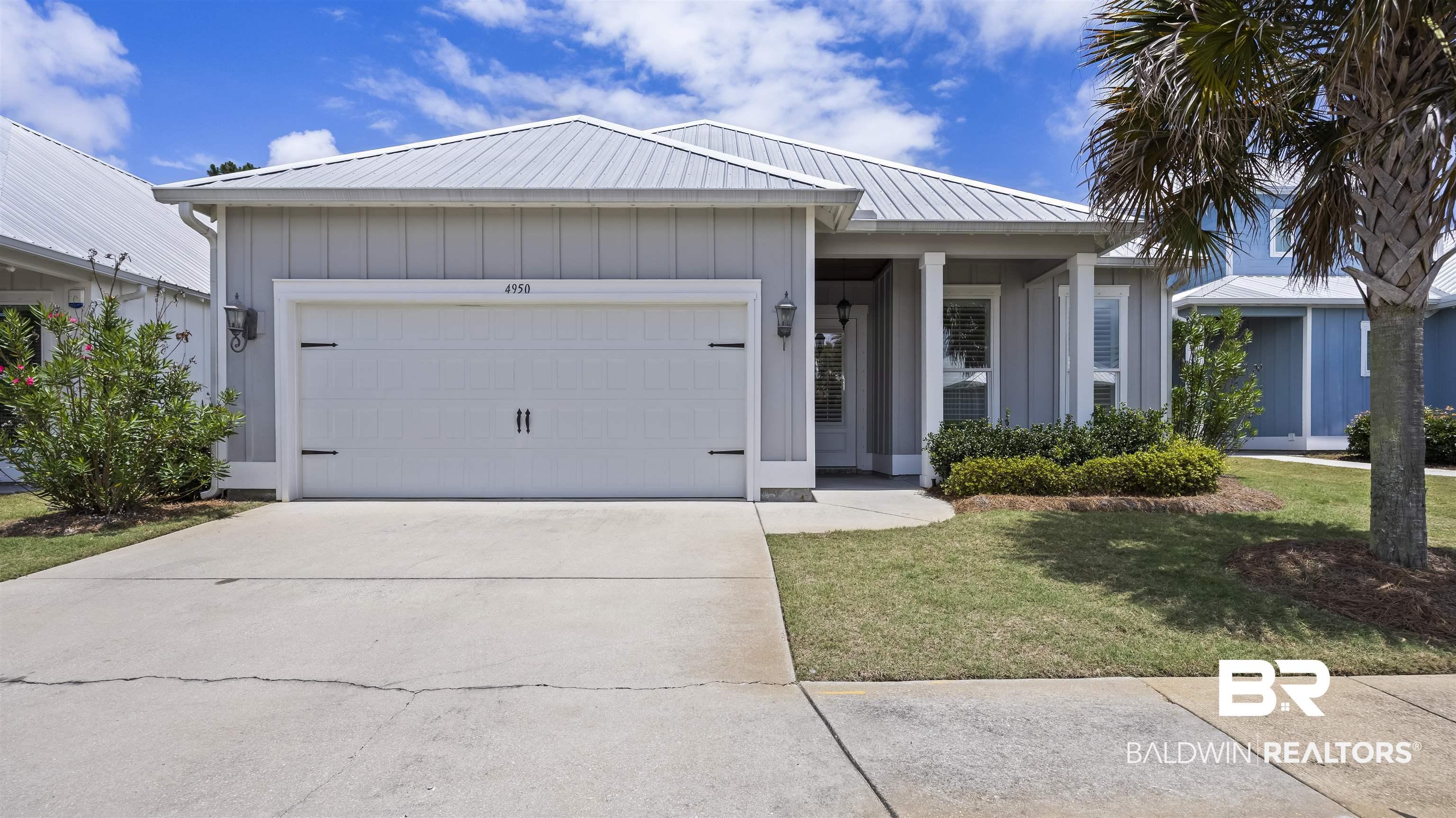 Image 1: Coastal-inspired exterior with light gray vertical siding and a silver metal roof