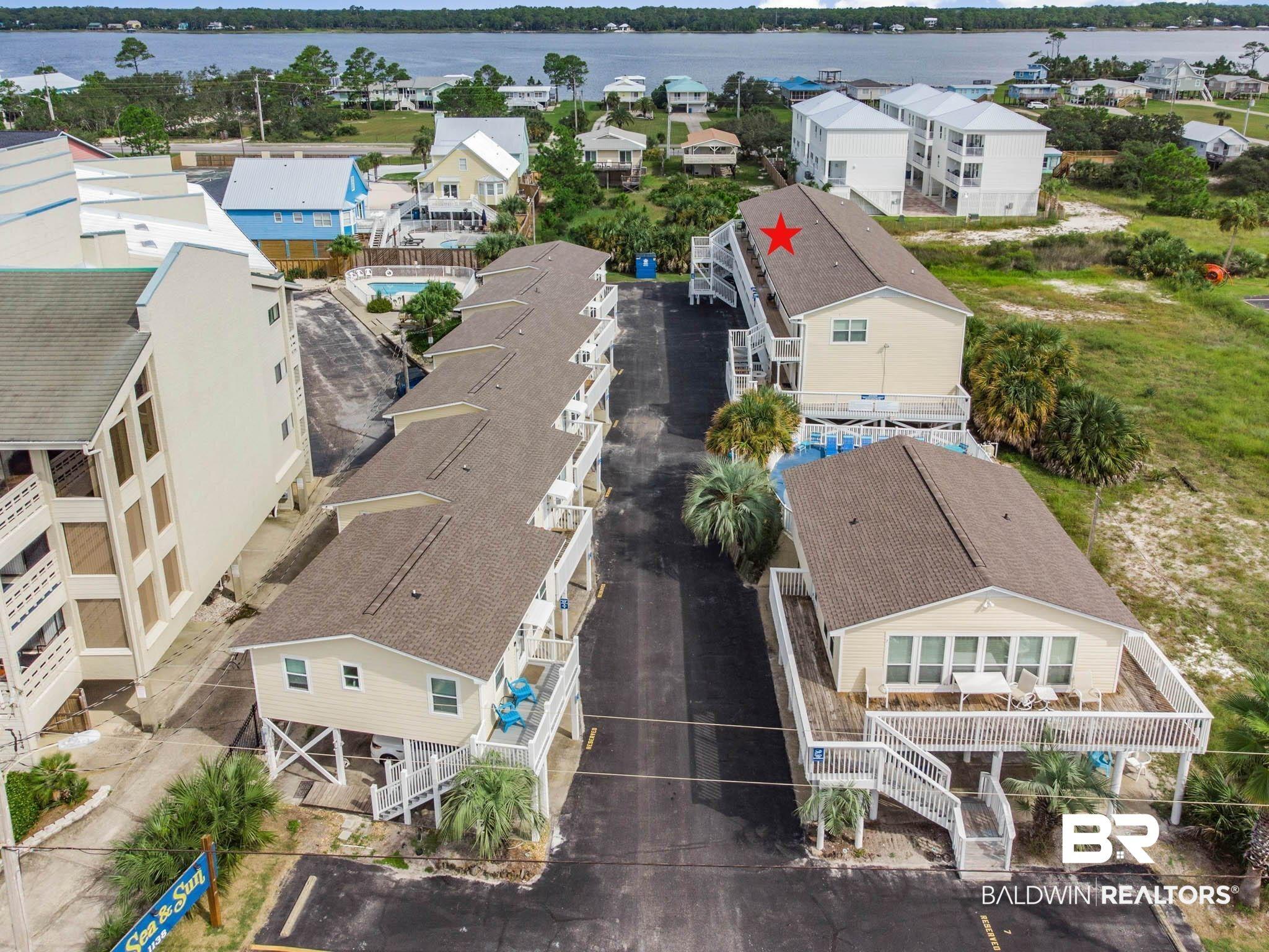 Image 3: Aerial view of residential area featuring a nearby body of water