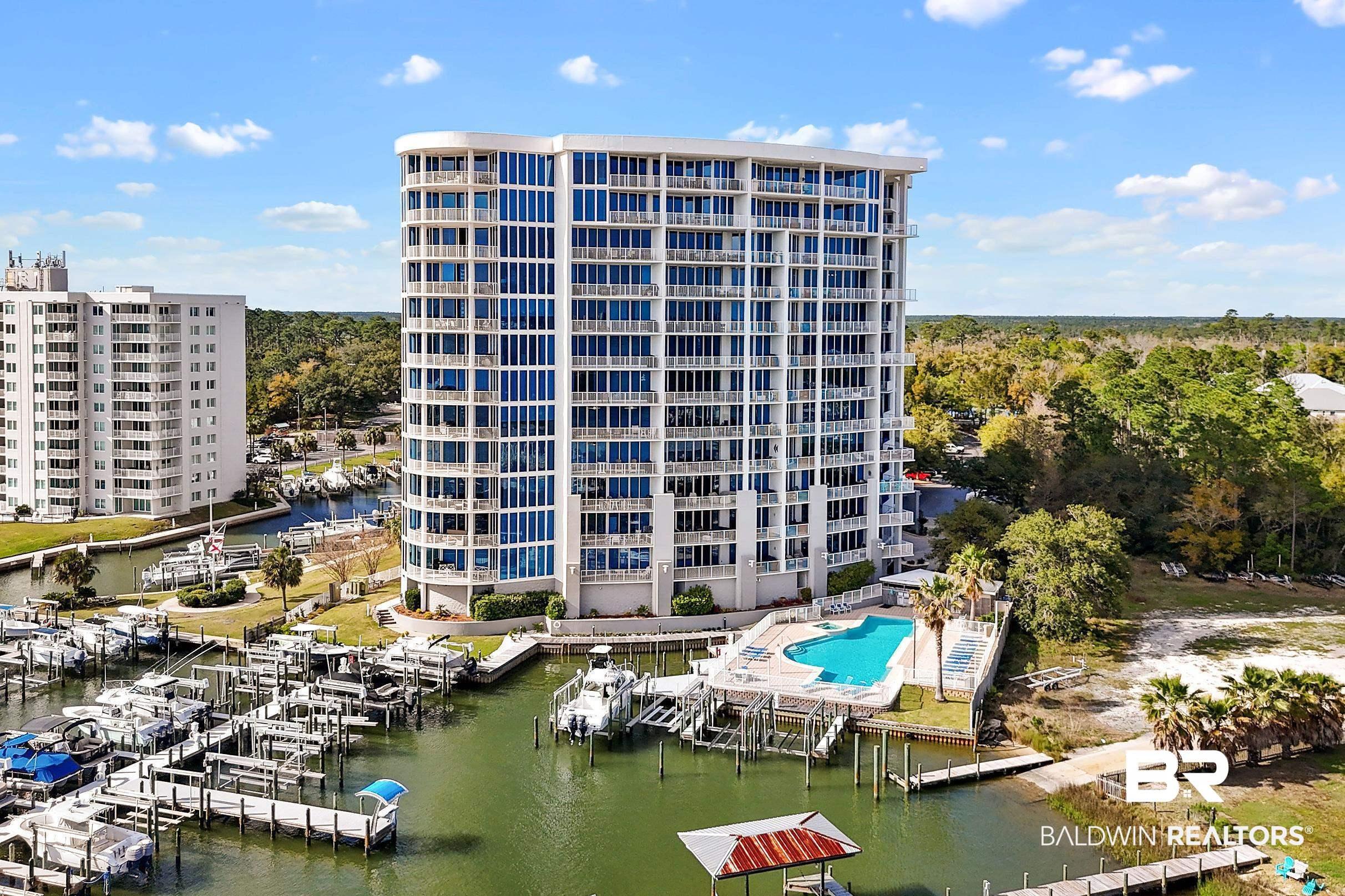 Image 1: View of apartment building / complex featuring a water view, boat lift, and view of marina