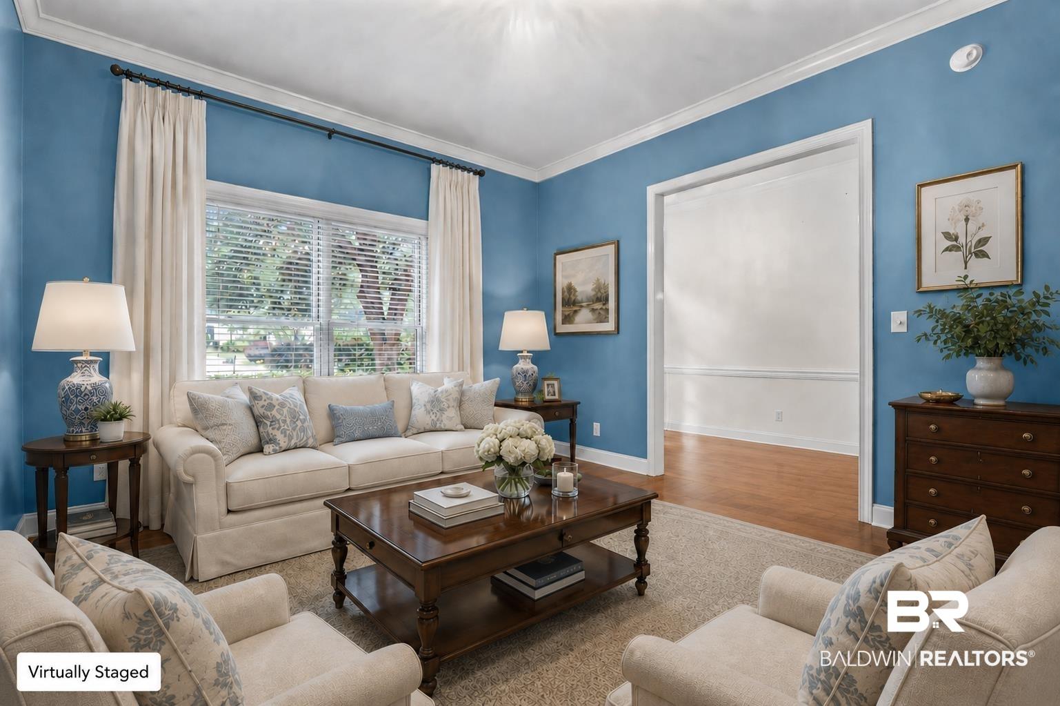 Image 2: Open living area featuring a wide window with blinds, crown molding, and a spacious doorway opening. This photo was virtually staged.