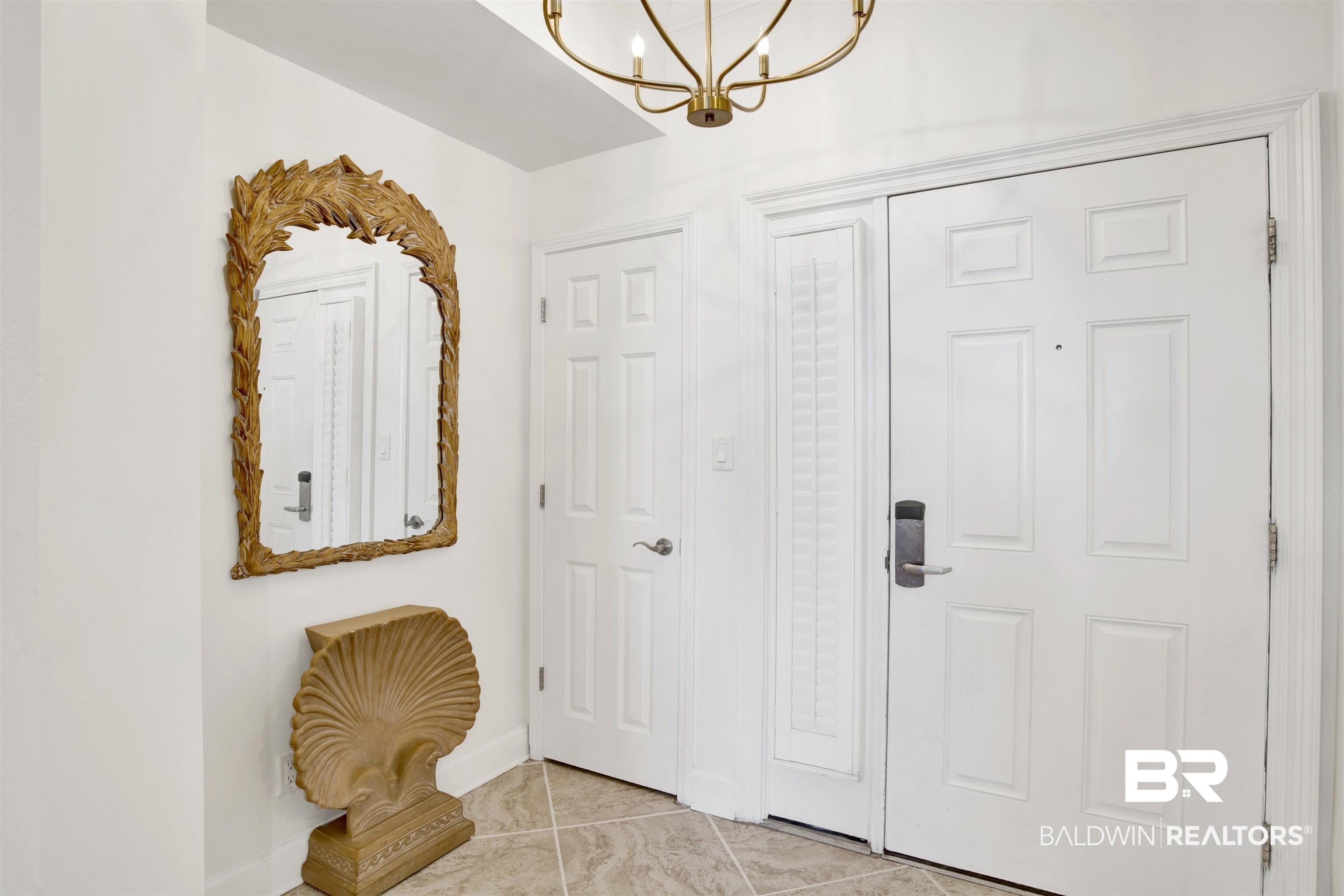 Image 4: Entryway with suspended lighting and light tile patterned floors