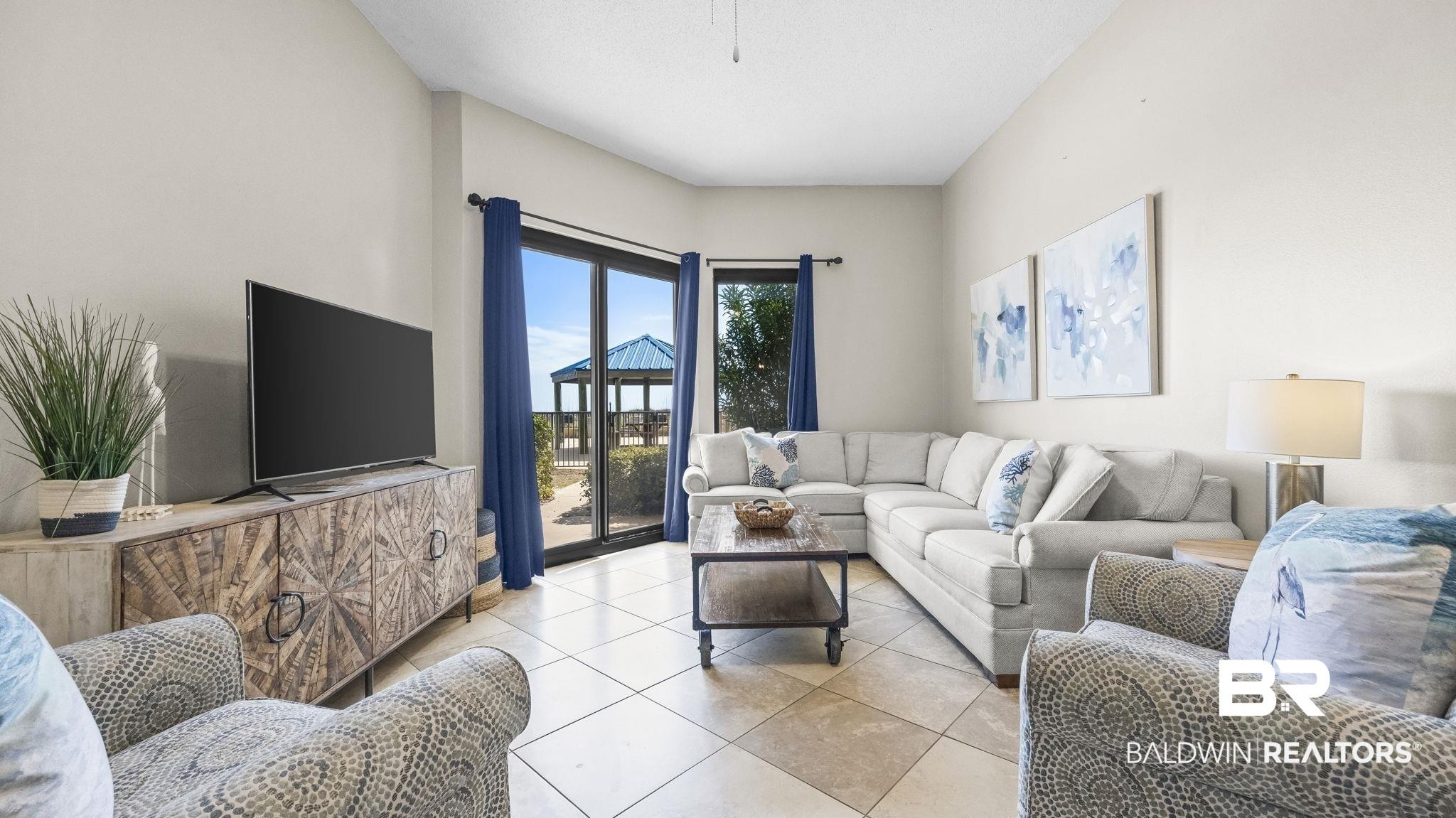 Image 2: Living room featuring light tile patterned flooring