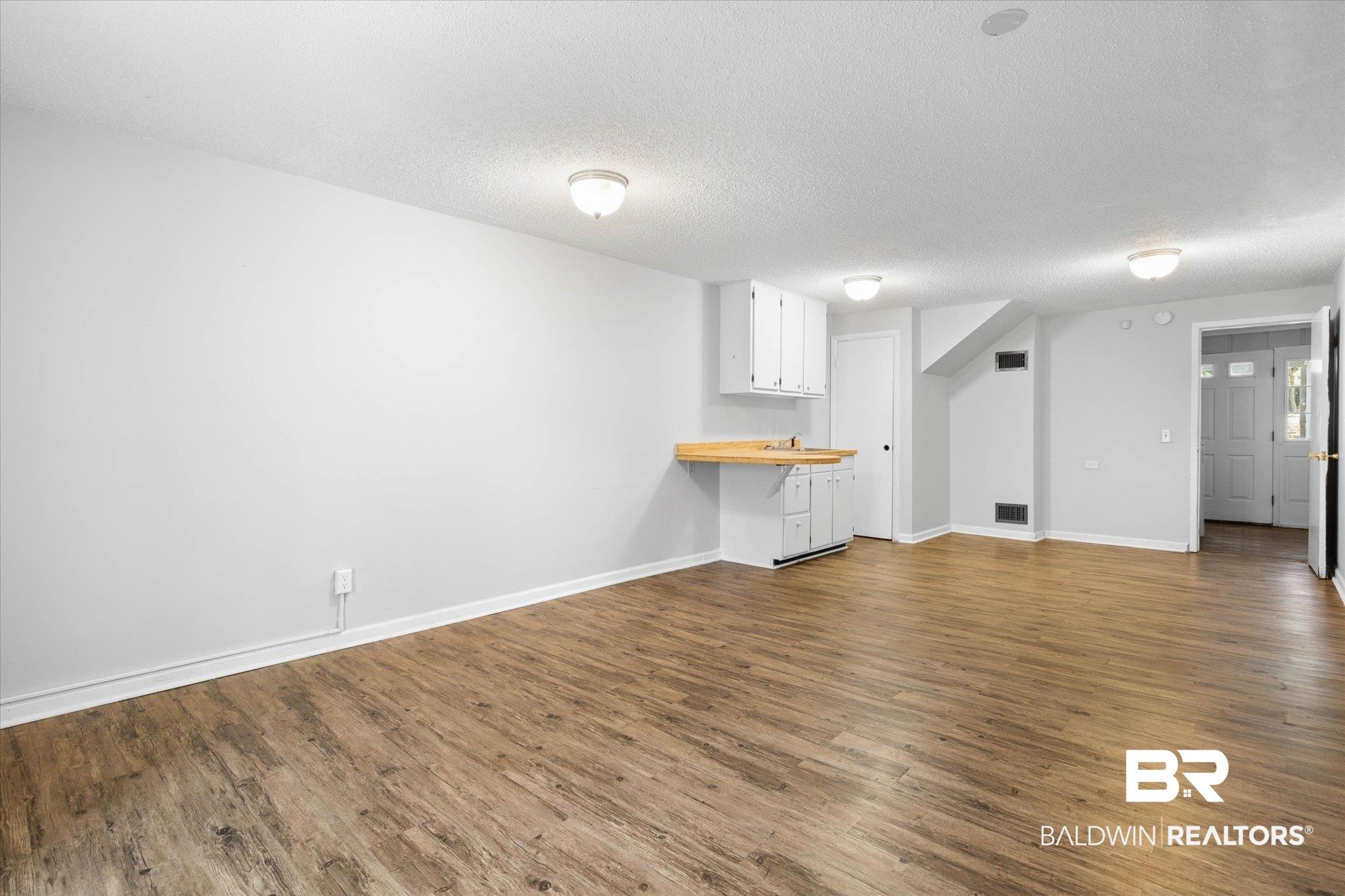 Image 4: Unfurnished living room featuring wood finished floors and a textured ceiling
