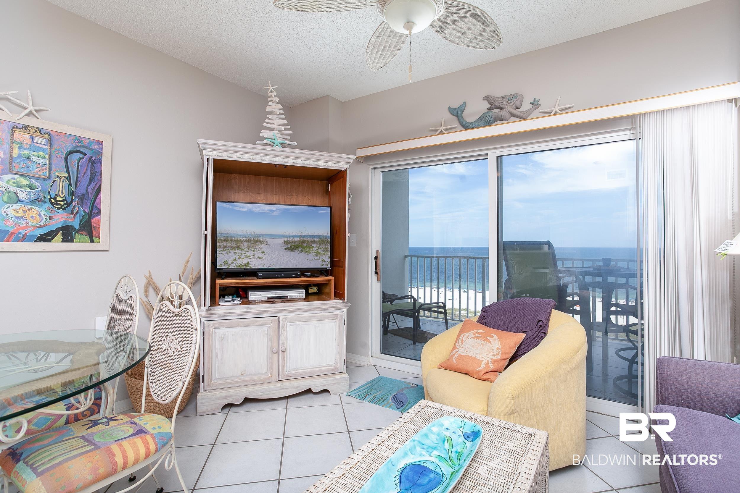 Image 2: Living area with light tile patterned flooring, ceiling fan, and a textured ceiling