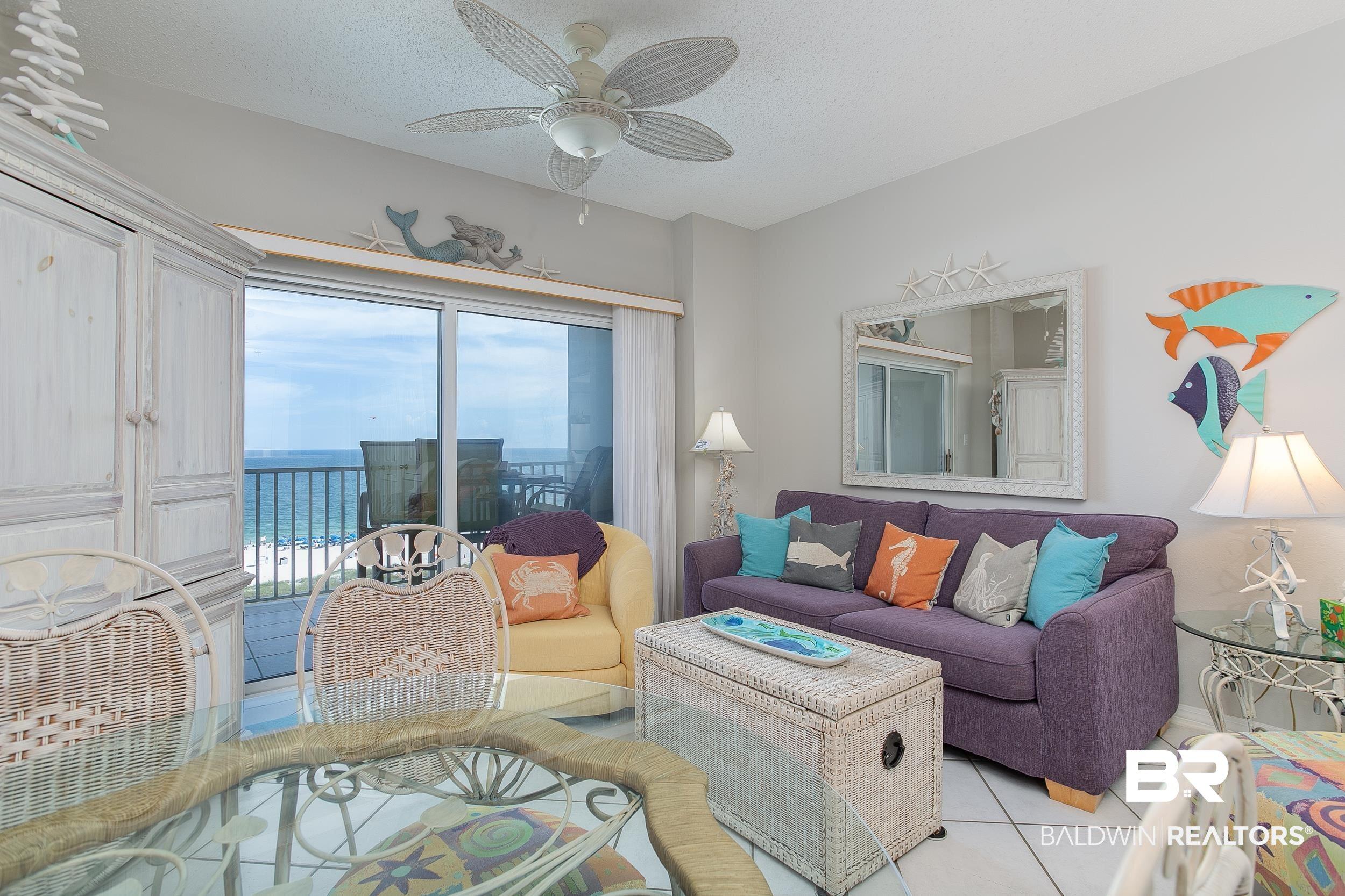 Image 4: Living room with light tile patterned floors, ceiling fan, a textured ceiling, and a water view