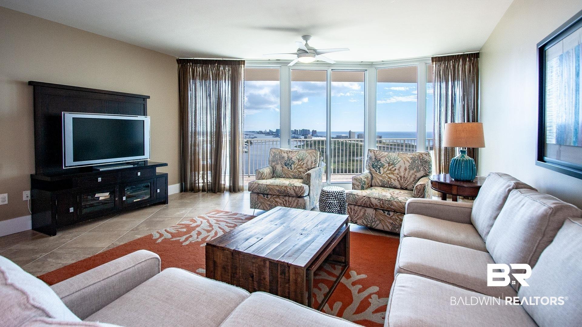 Image 2: Living area featuring ceiling fan, healthy amount of natural light, tile patterned floors, expansive windows, and baseboards