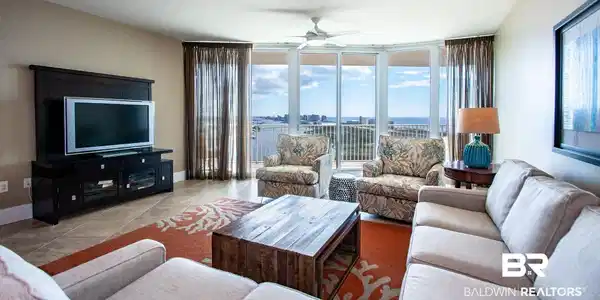 Image 2: Living area featuring ceiling fan, healthy amount of natural light, tile patterned floors, expansive windows, and baseboards