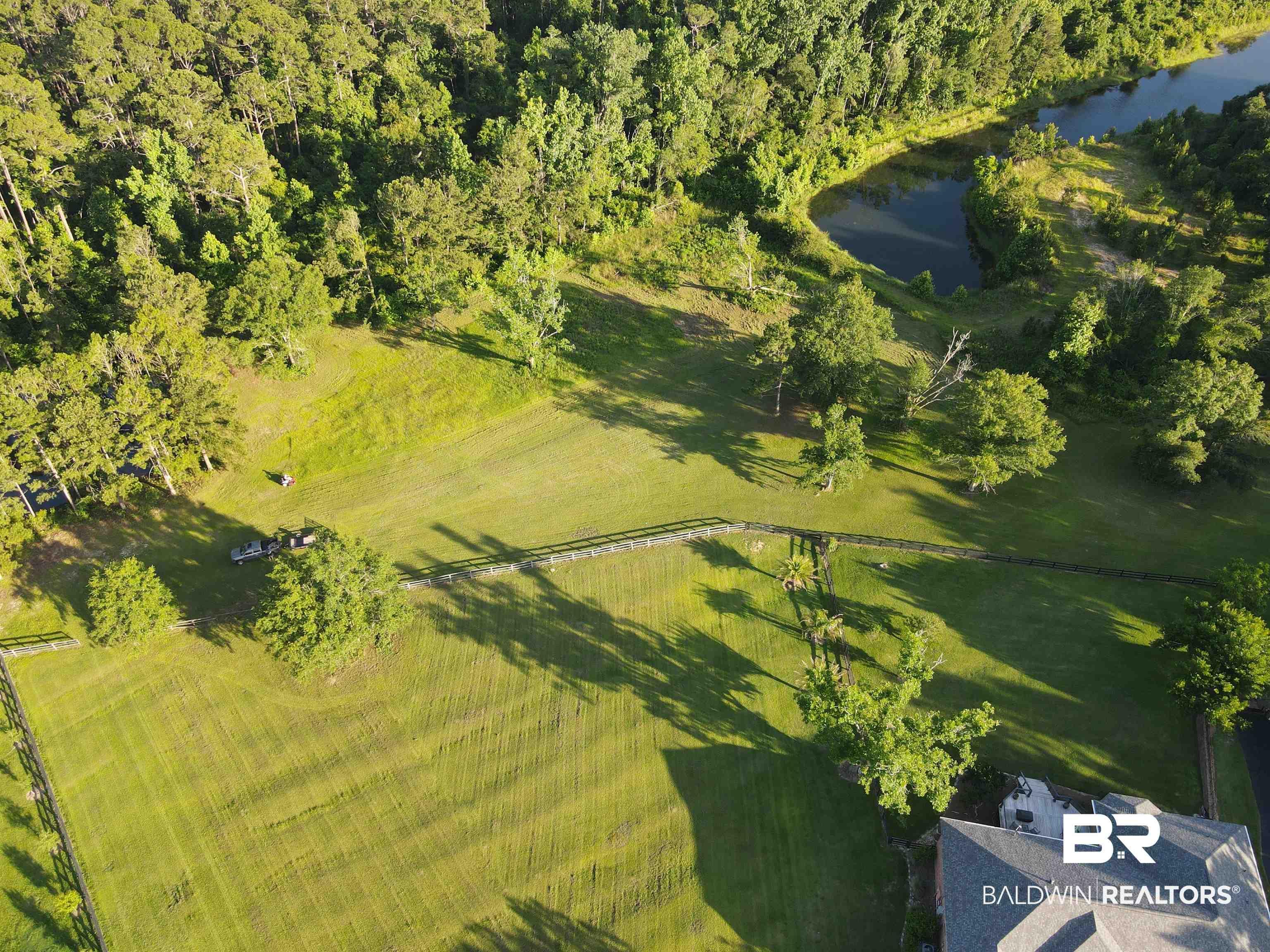 Image 2: Aerial overview of property's location featuring a nearby body of water and a forest