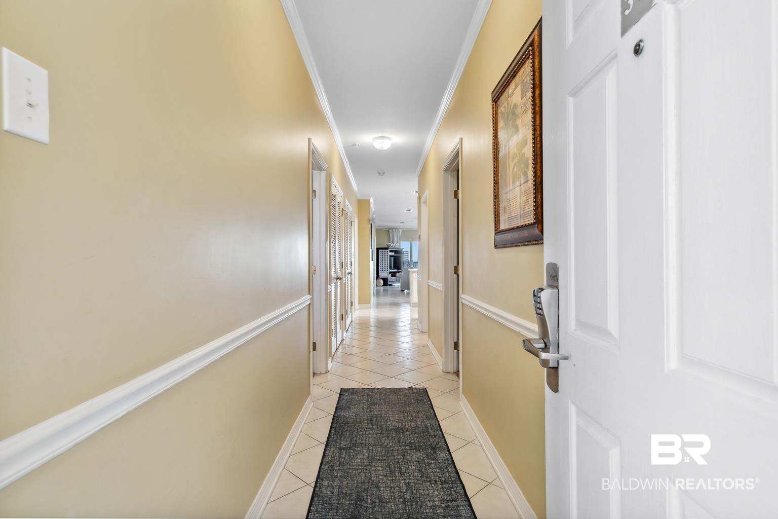 Image 2: Corridor featuring crown molding and light tile patterned floors