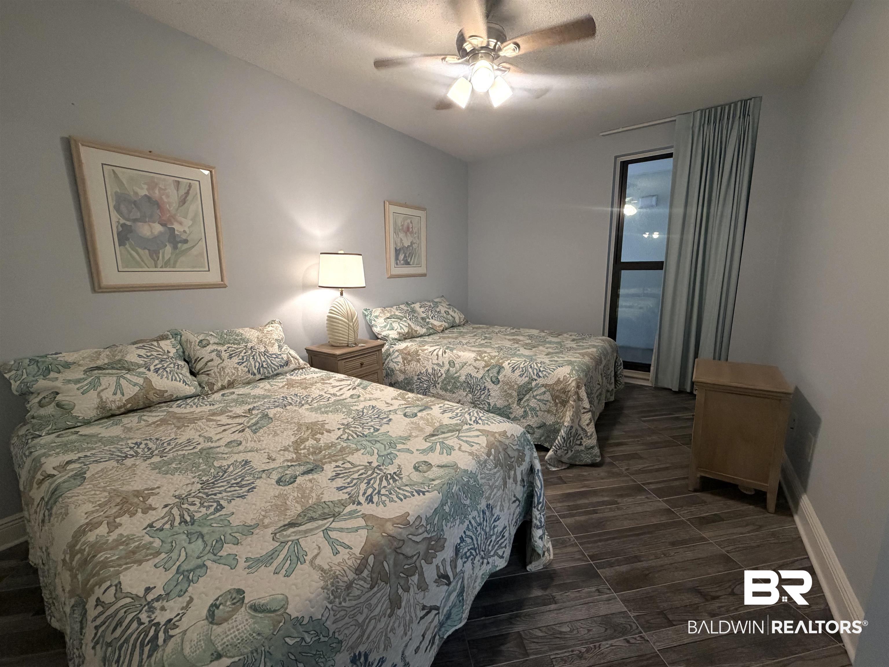Image 4: Bedroom featuring a textured ceiling, ceiling fan, and dark wood-style floors