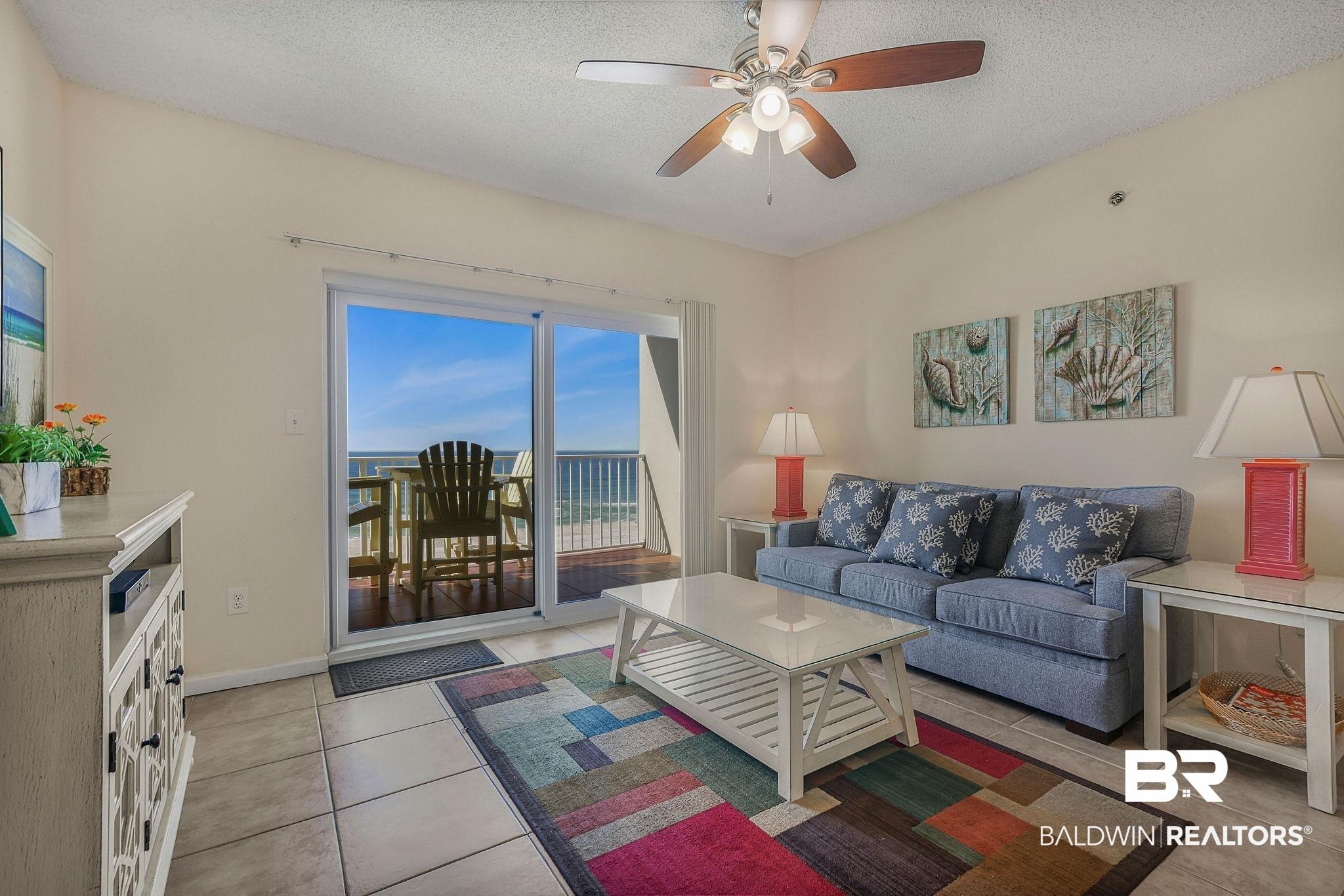 Image 3: Living area with a ceiling fan, a textured ceiling, and light tile patterned floors