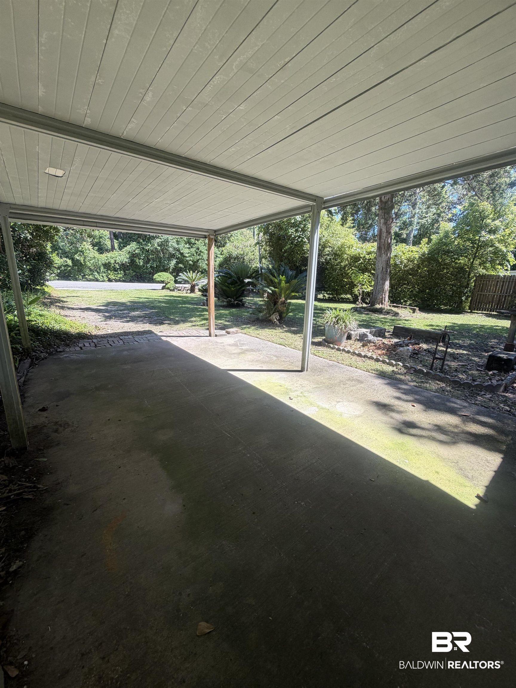 Image 3: Covered carport featuring a concrete pad