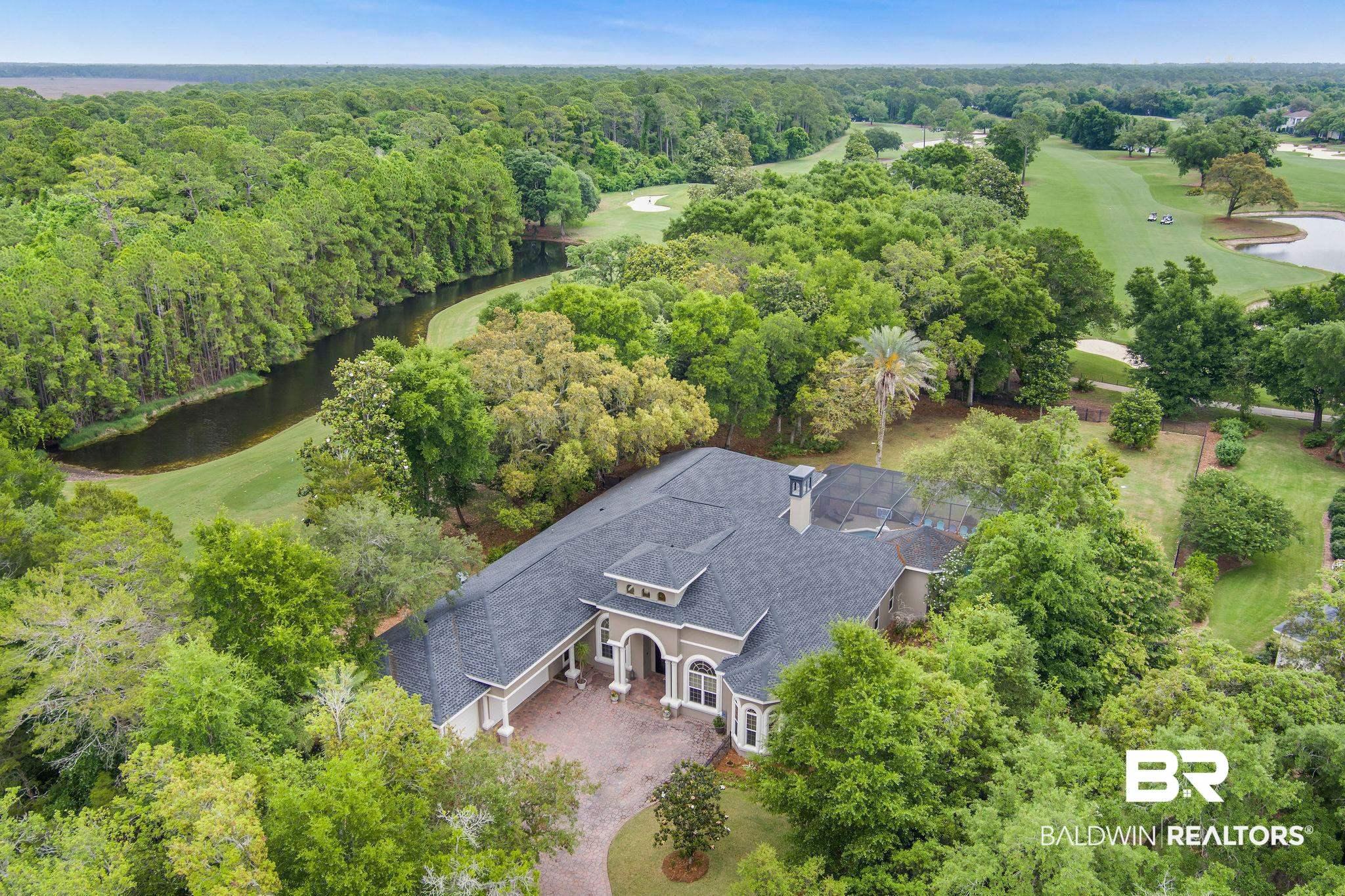 Image 3: Expansive property featuring a mature treeline, a golf course, and a meandering waterway