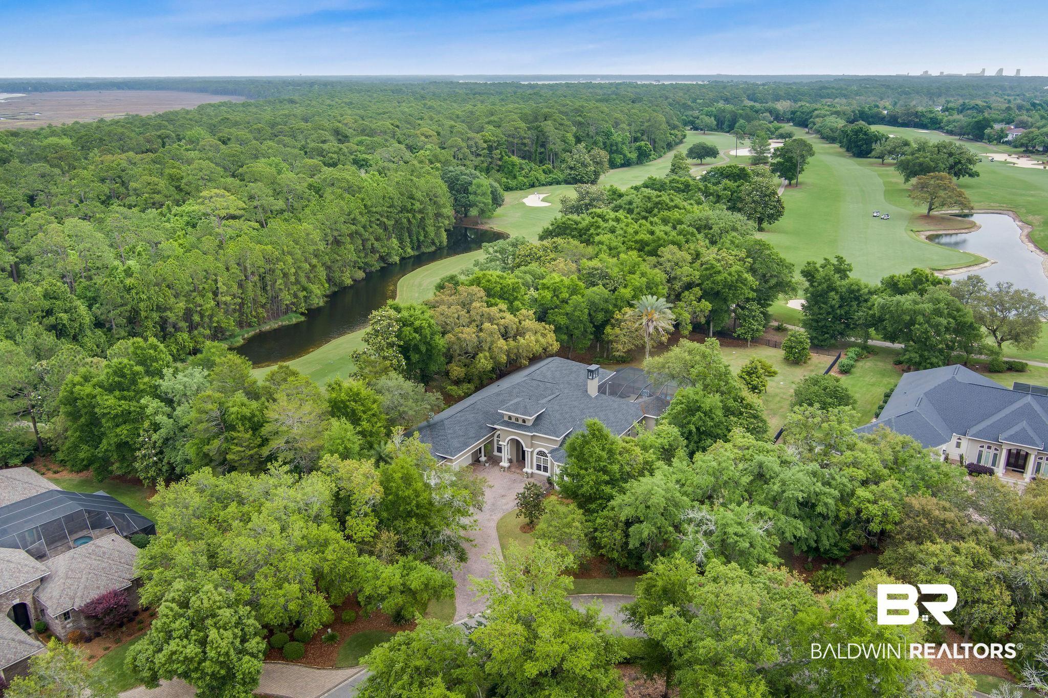 Image 4: Spacious residence surrounded by extensive foliage and a winding golf course