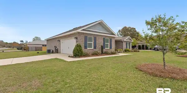 Image 2: Ranch-style house with brick siding, a front lawn, driveway, and a garage