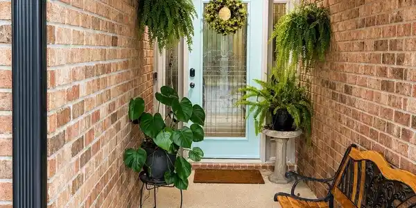 Image 3: Covered front entry featuring a light blue door with sidelights, brick exterior, speckled concrete flooring, and a white soffit ceiling
