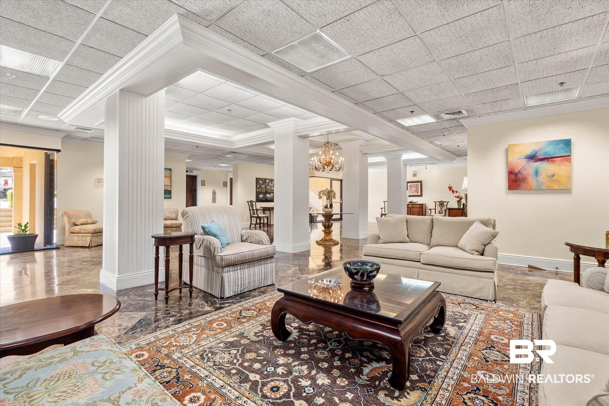 Image 2: The lobby features a wide-open foyer with living room area. Marble Floors and beautiful decor.