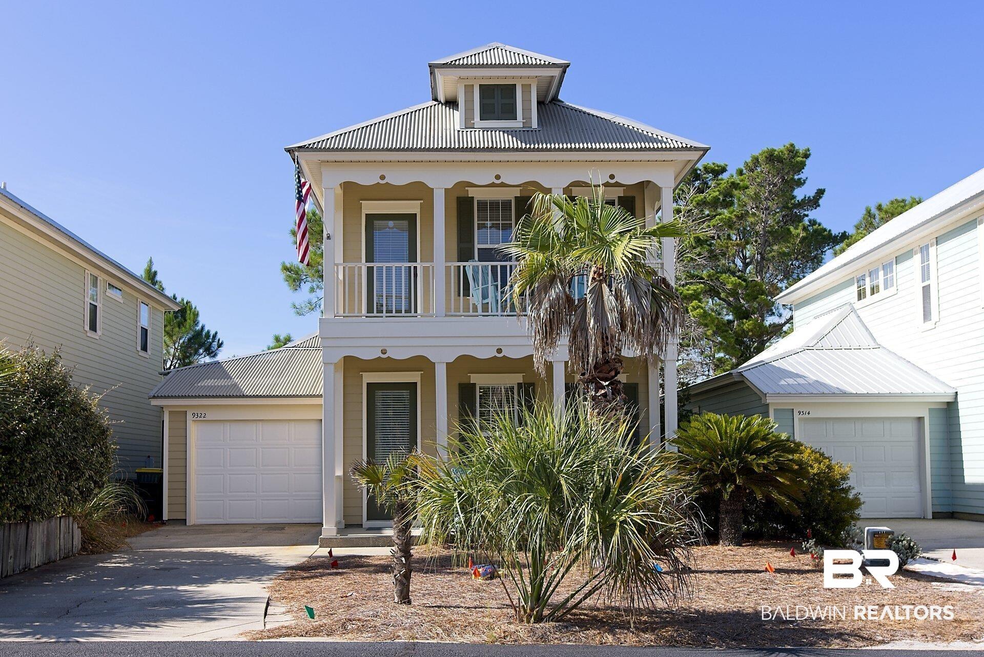Image 2: View of front of house with a balcony,  a covered entrance and upstairs balcony, an attached garage, and low maintenance hardi plank siding