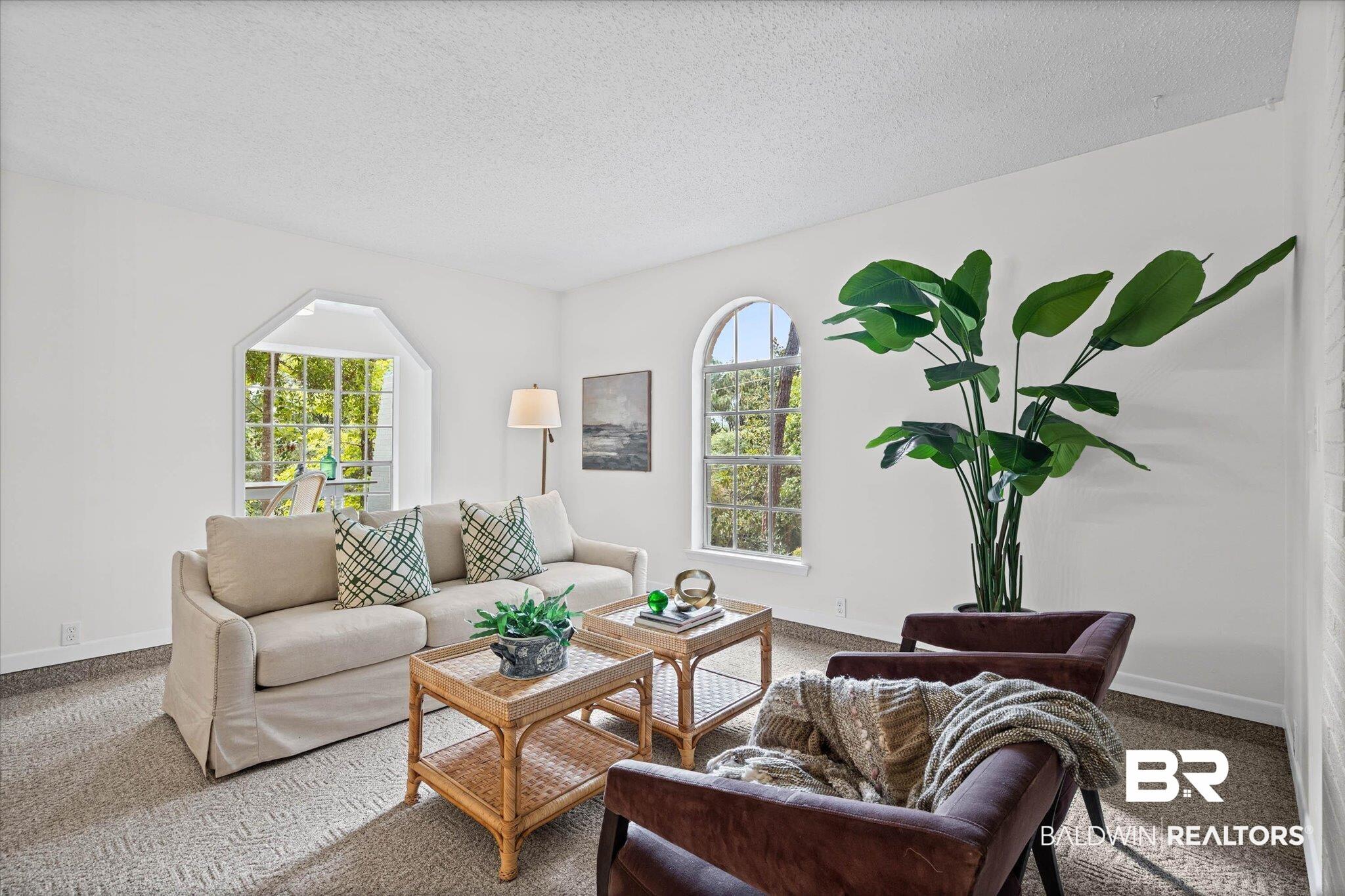 Image 3: Living area featuring light-toned walls and patterned carpeting