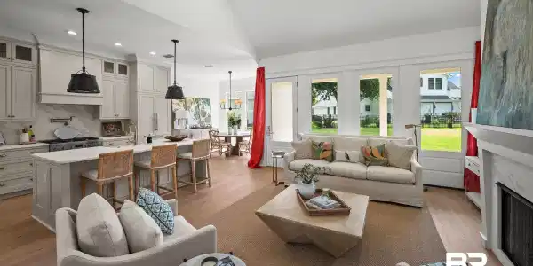 Image 3: Vaulted living space with light wood-finish flooring, a contemporary ceiling fan, and a built-in fireplace