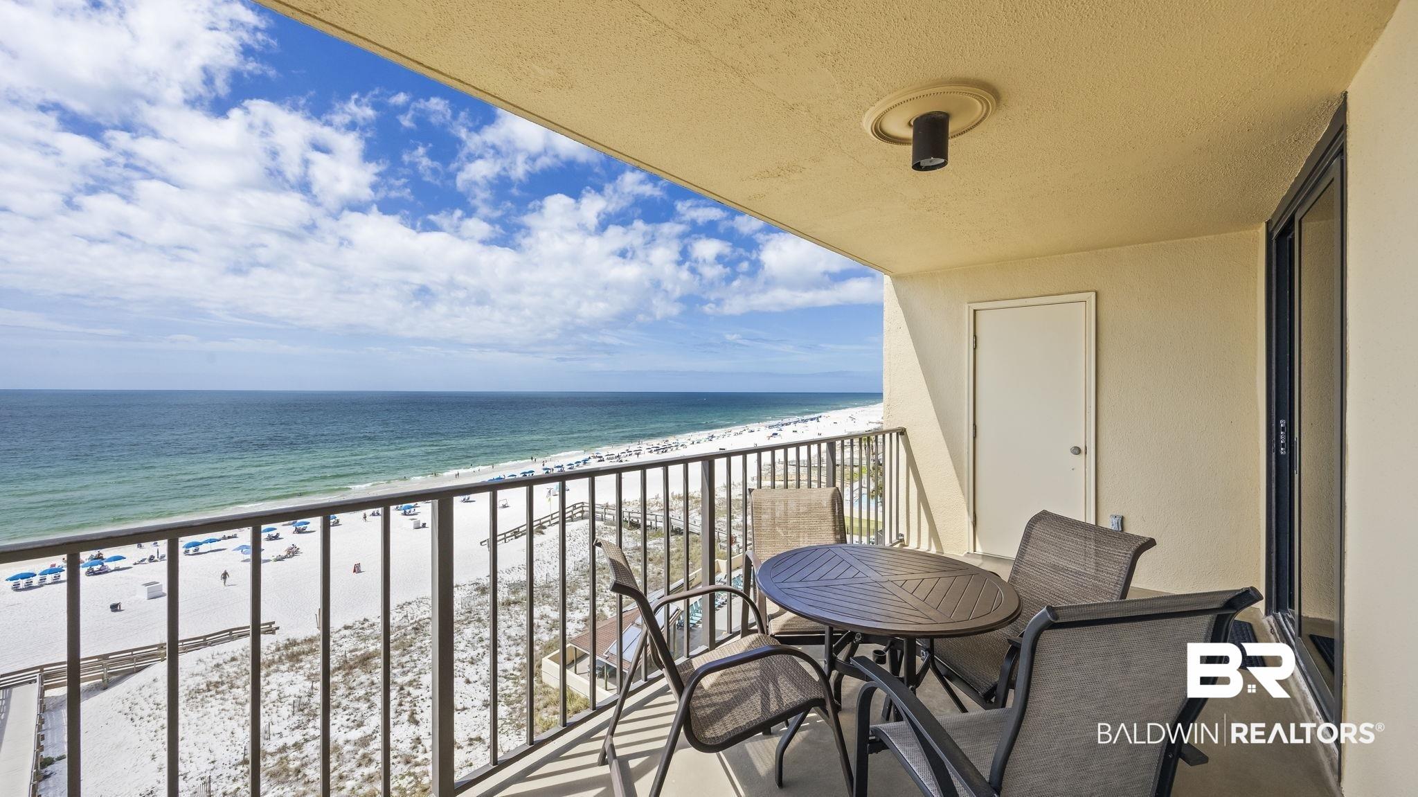 Image 3: Balcony featuring view of water and beach and outdoor dining space