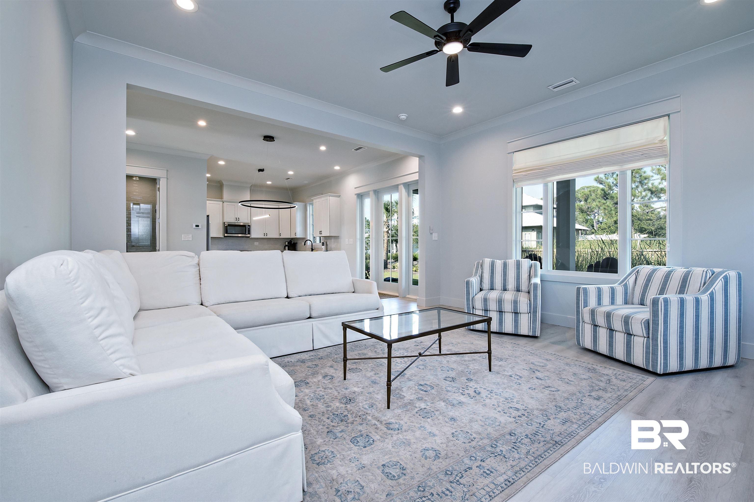 Image 4: Bright living area featuring light wood-finish flooring and recessed lighting