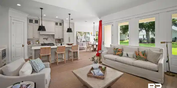 Image 4: Spacious living area featuring high vaulted ceilings, light wood-finish flooring, and a bank of large windows