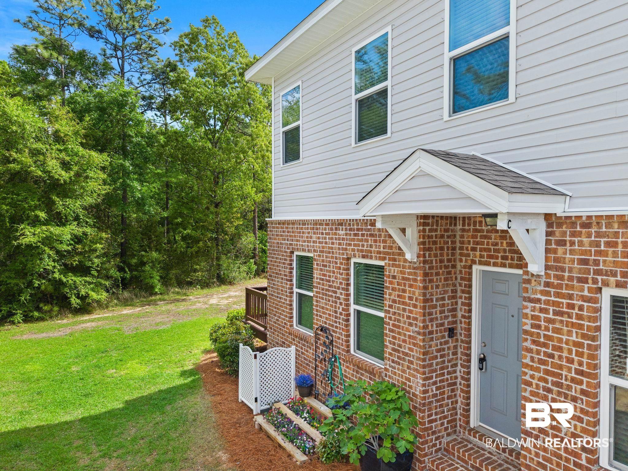 Image 4: View of exterior entry featuring a yard and brick siding