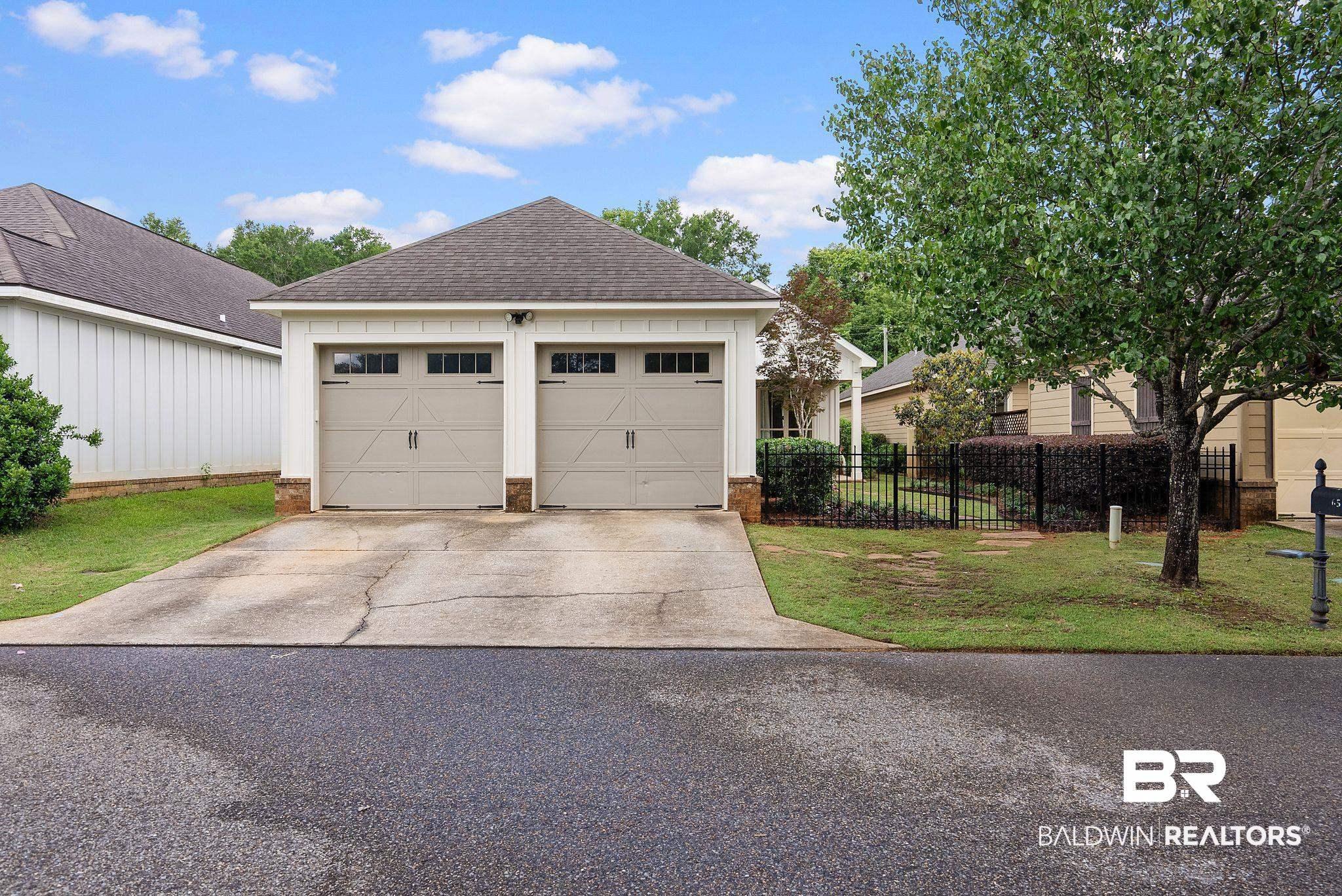Image 3: Two-car garage with carriage-style doors and upper window panels