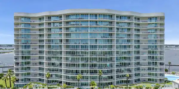 Image 2: Modern high-rise condominium building featuring an undulating facade and full-height glass balconies