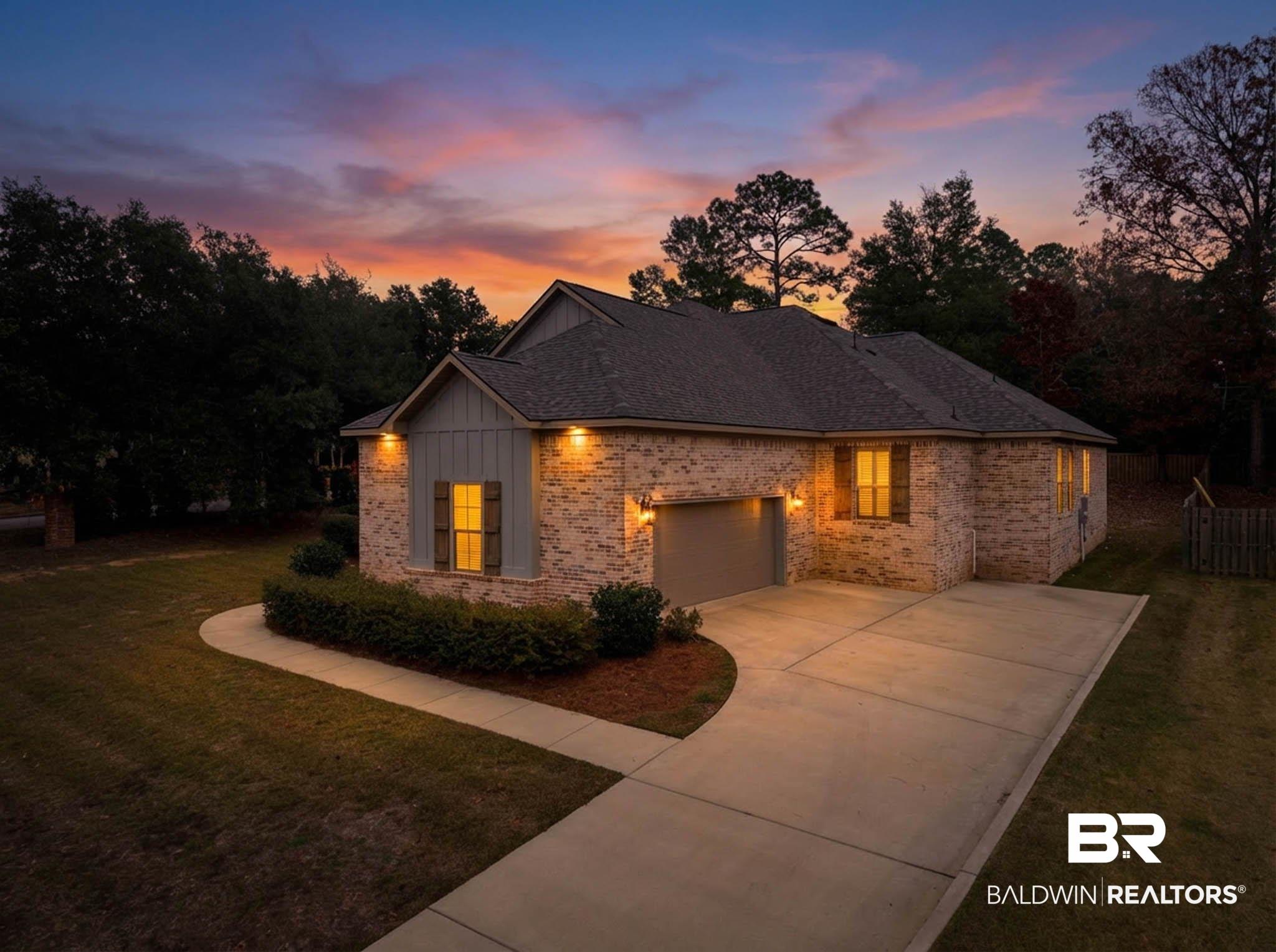Image 2: View of front of property featuring a yard, concrete driveway, and brick siding