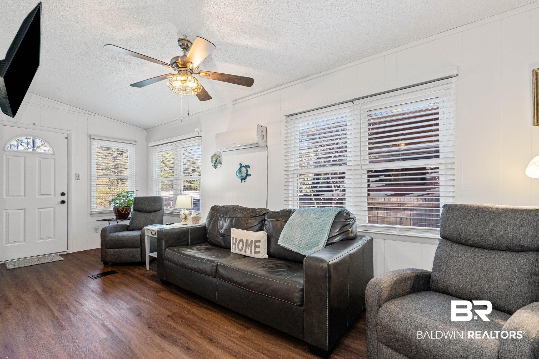 Image 2: Living room featuring wood finished floors, a textured ceiling, vaulted ceiling, healthy amount of natural light, and a ceiling fan