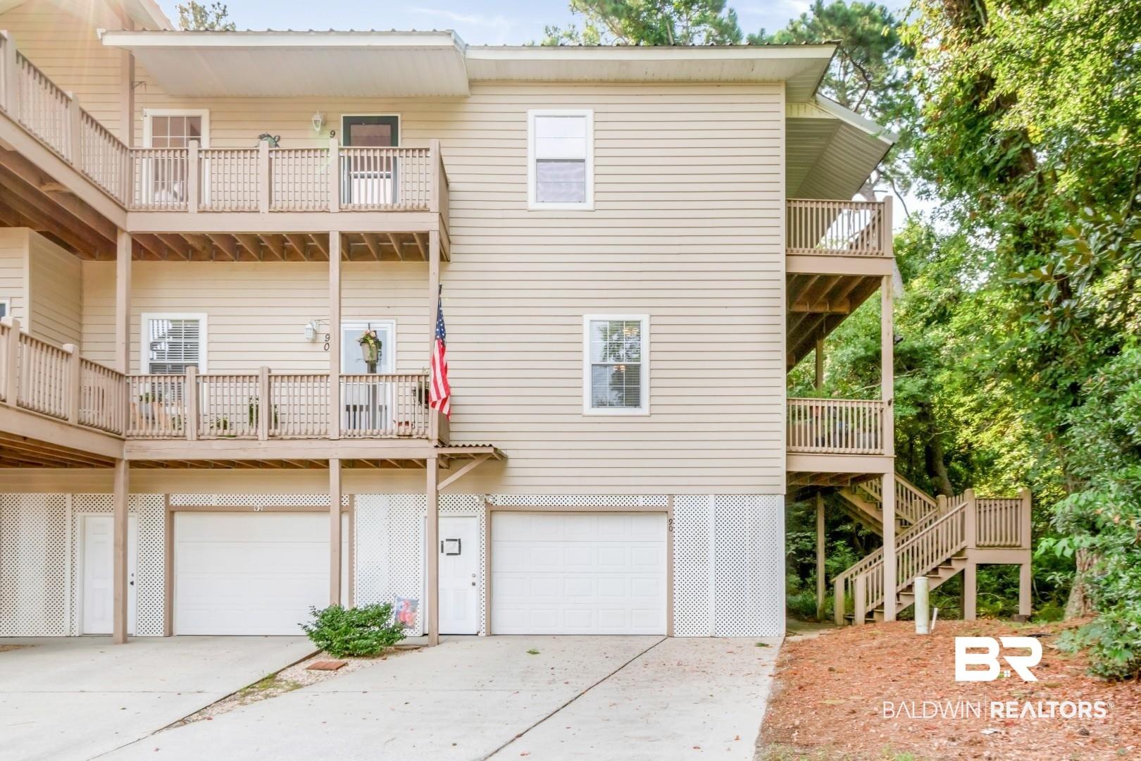 Image 2: Multi-level structure featuring light beige siding and multiple balconies
