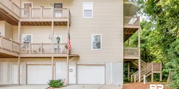 Image 2: Multi-level structure featuring light beige siding and multiple balconies