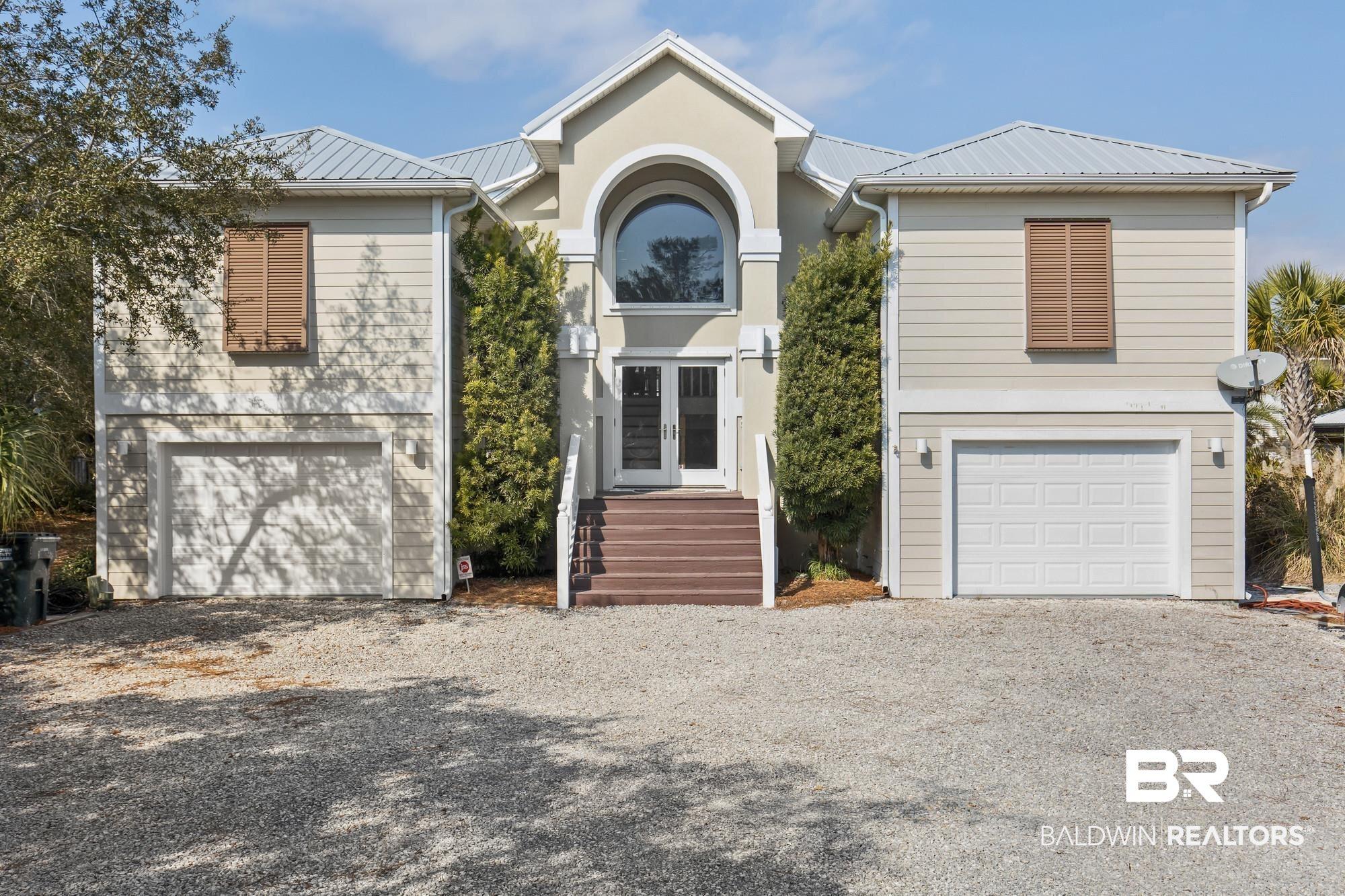 Image 1: View of front of house featuring a metal roof, french doors, driveway, and a garage