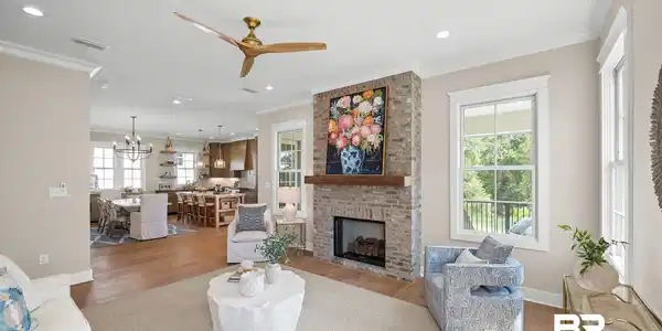 Image 3: Living area featuring a brick fireplace with a wood mantel, recessed lighting, and a multi-blade ceiling fan