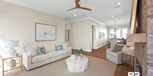 Image 4: Living area featuring wood-finish flooring, a ceiling fan, crown molding, recessed lighting, and an exposed brick fireplace with a wood mantle