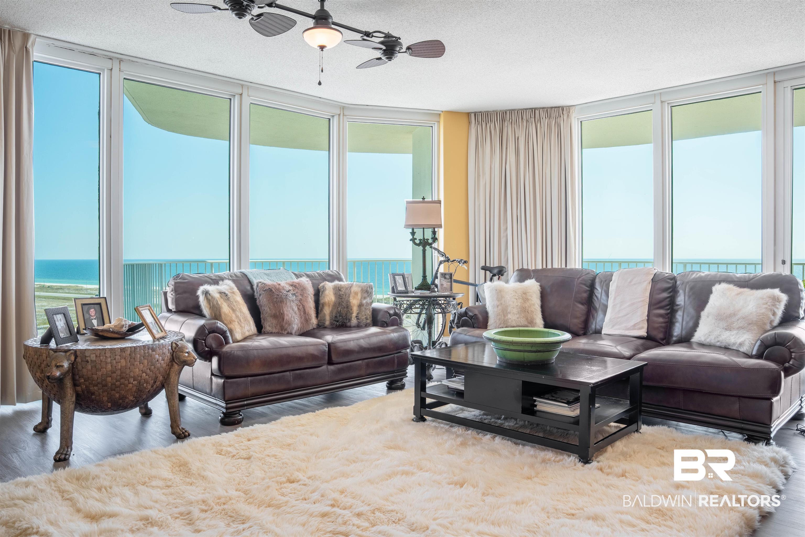 Image 2: Living area featuring floor to ceiling windows, a water view, wood finished floors, a textured ceiling, and ceiling fan
