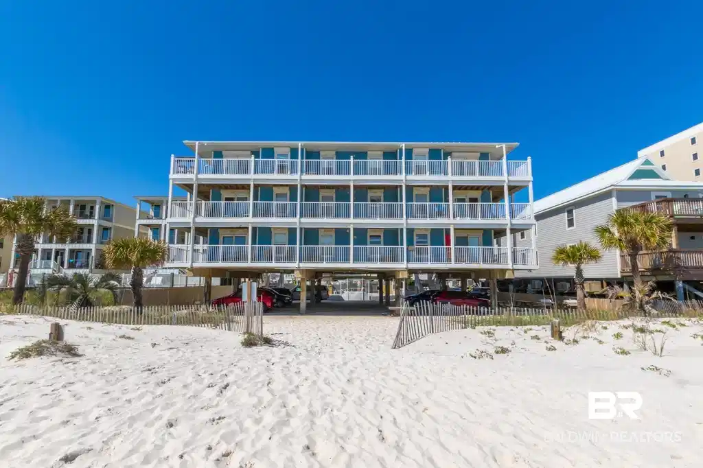 Image 1: Beachfront multi-story structure featuring multiple balconies with white railings