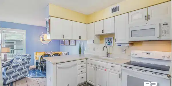 Image 3: Kitchen featuring white cabinetry, a flat-top electric range, a built-in microwave, a dishwasher, and a double basin sink