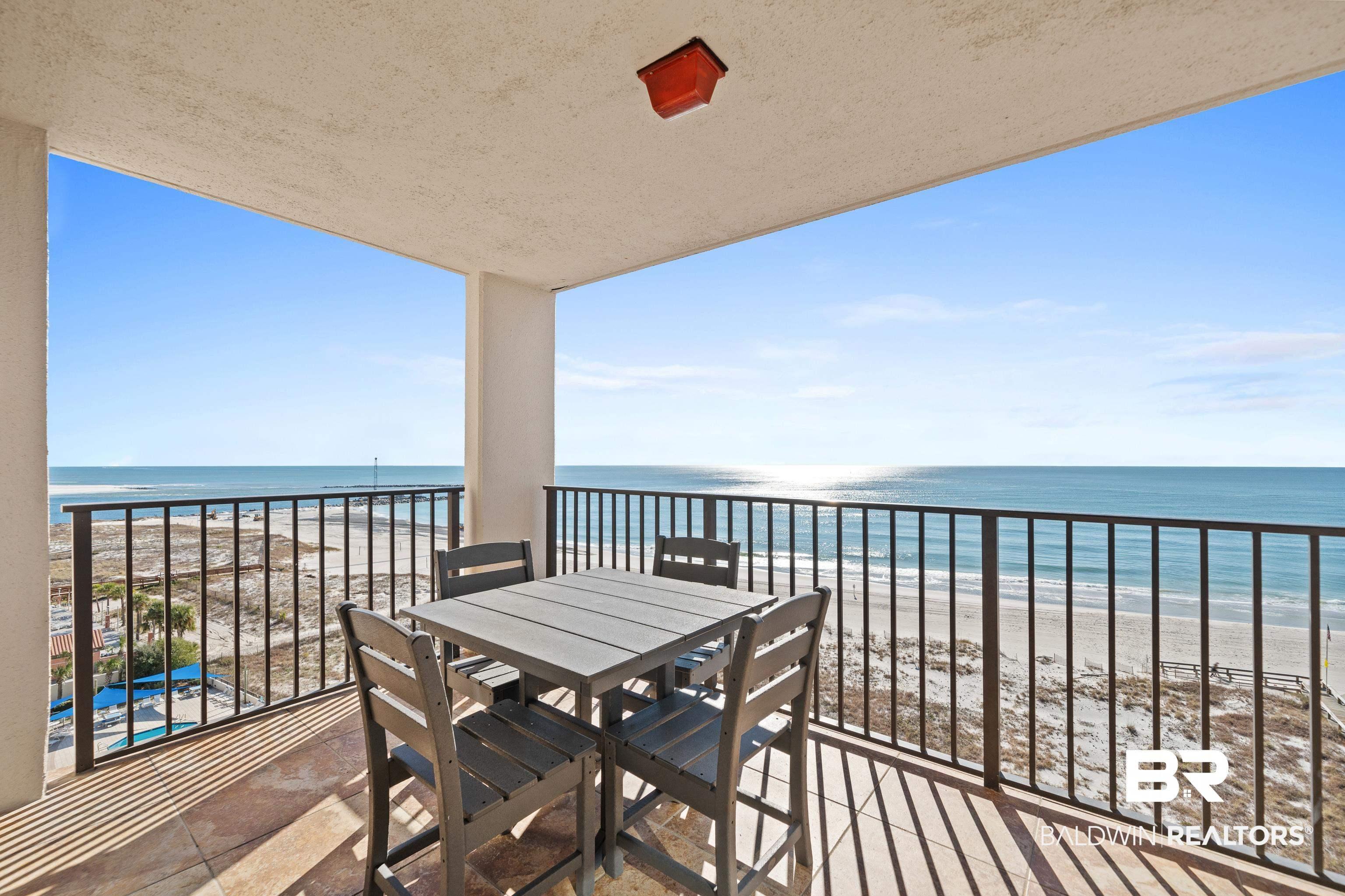 Image 3: Balcony featuring outdoor dining space and view of water and beach