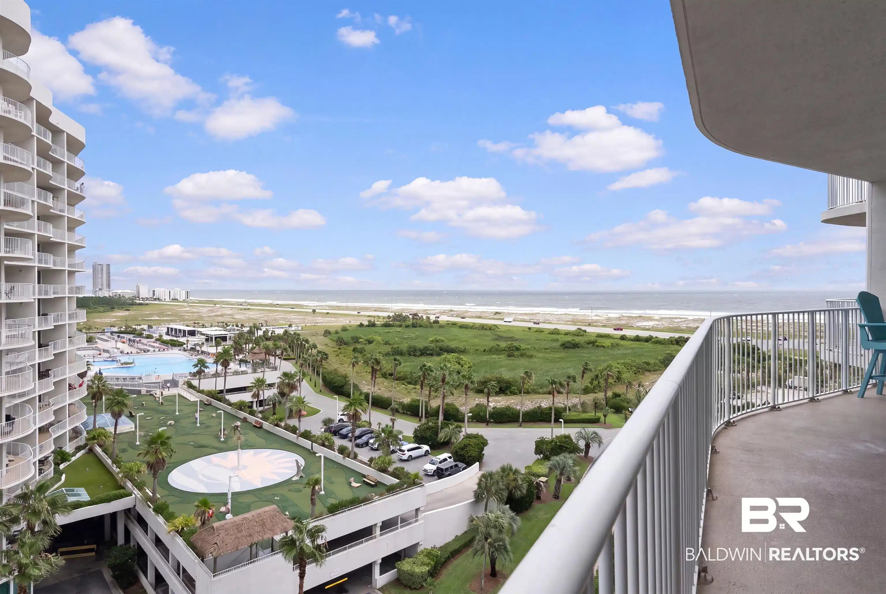 Image 1: Expansive balcony overlooking the Gulf of Mexico, coastal landscape, and resort-style amenities