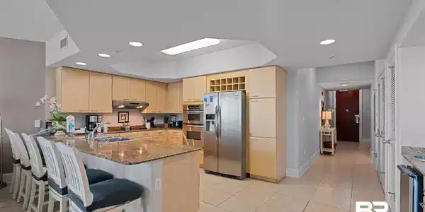 Image 4: Kitchen featuring light wood cabinetry, a large center island with a stone countertop, recessed lighting, and stainless steel appliances