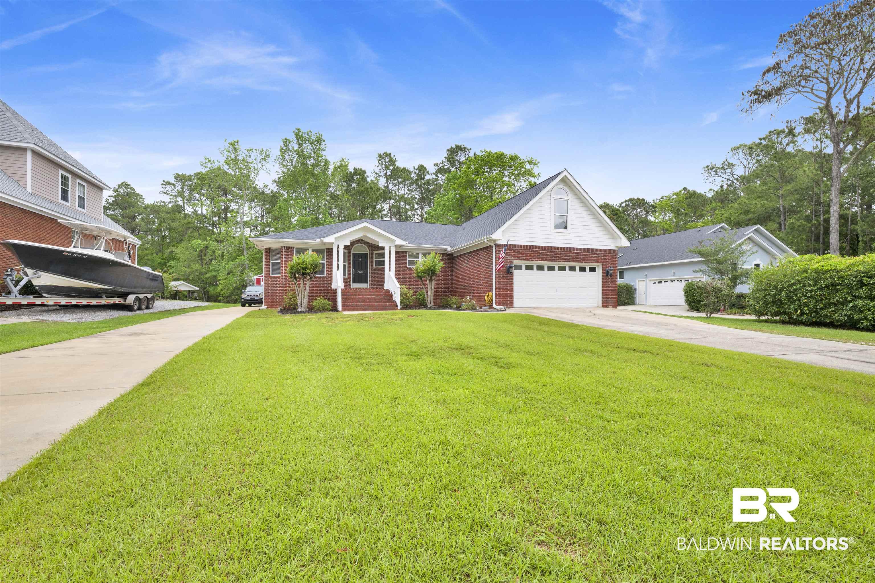 Image 2: Ranch-style home with concrete driveway, brick siding, a front lawn, and an attached garage