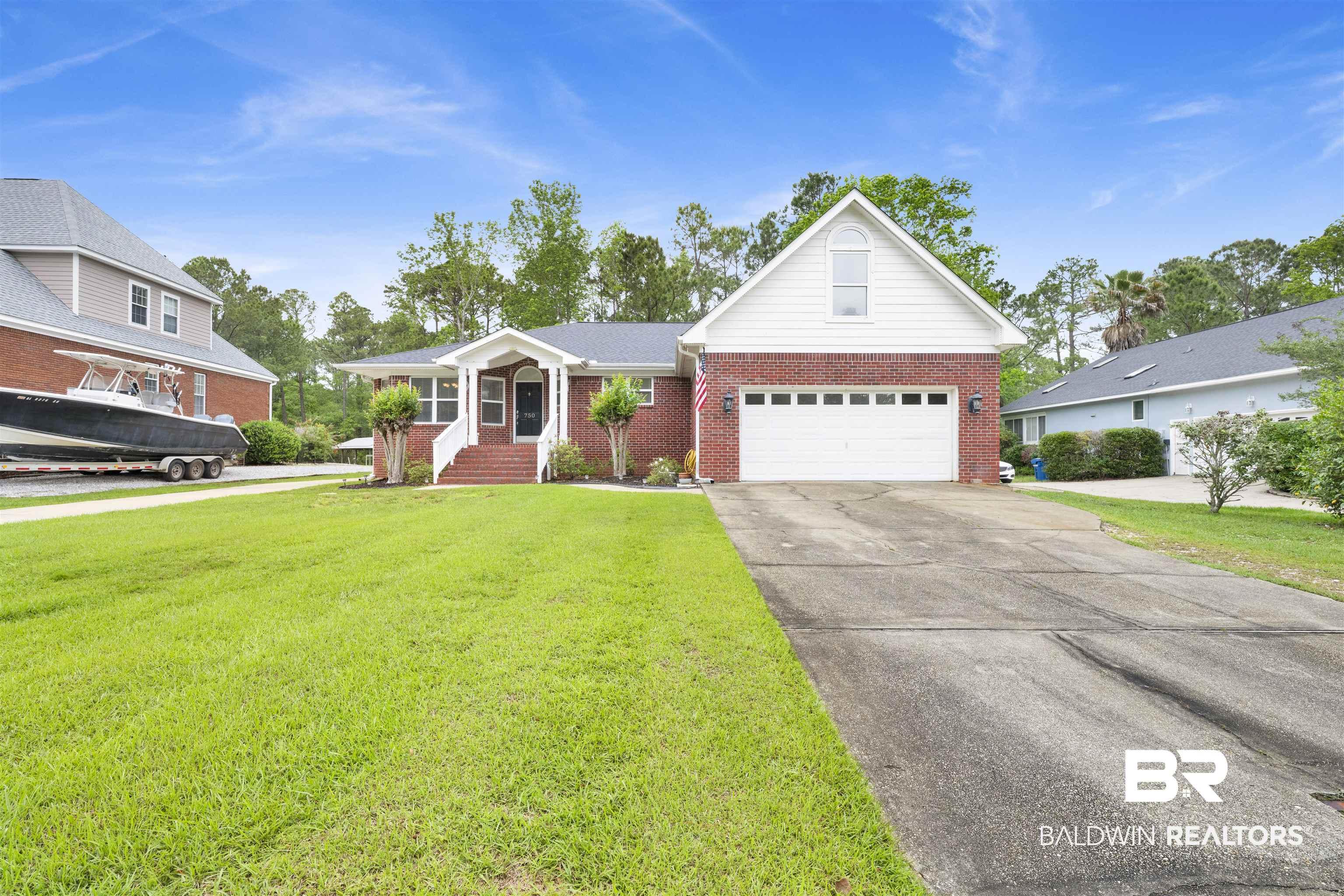 Image 3: Single story home with brick siding, driveway, a garage, and a front lawn