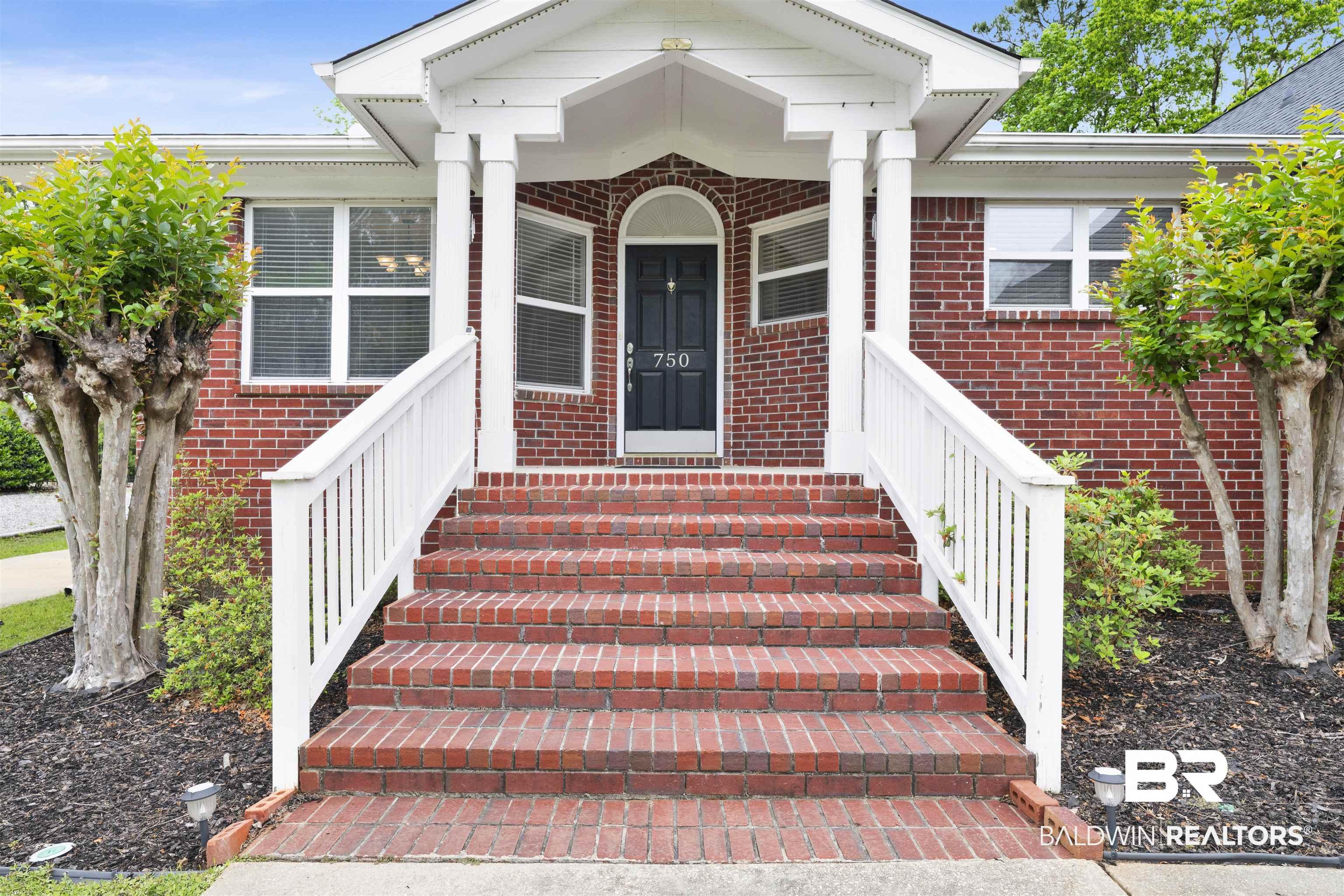 Image 4: View of exterior entry featuring a porch and brick siding