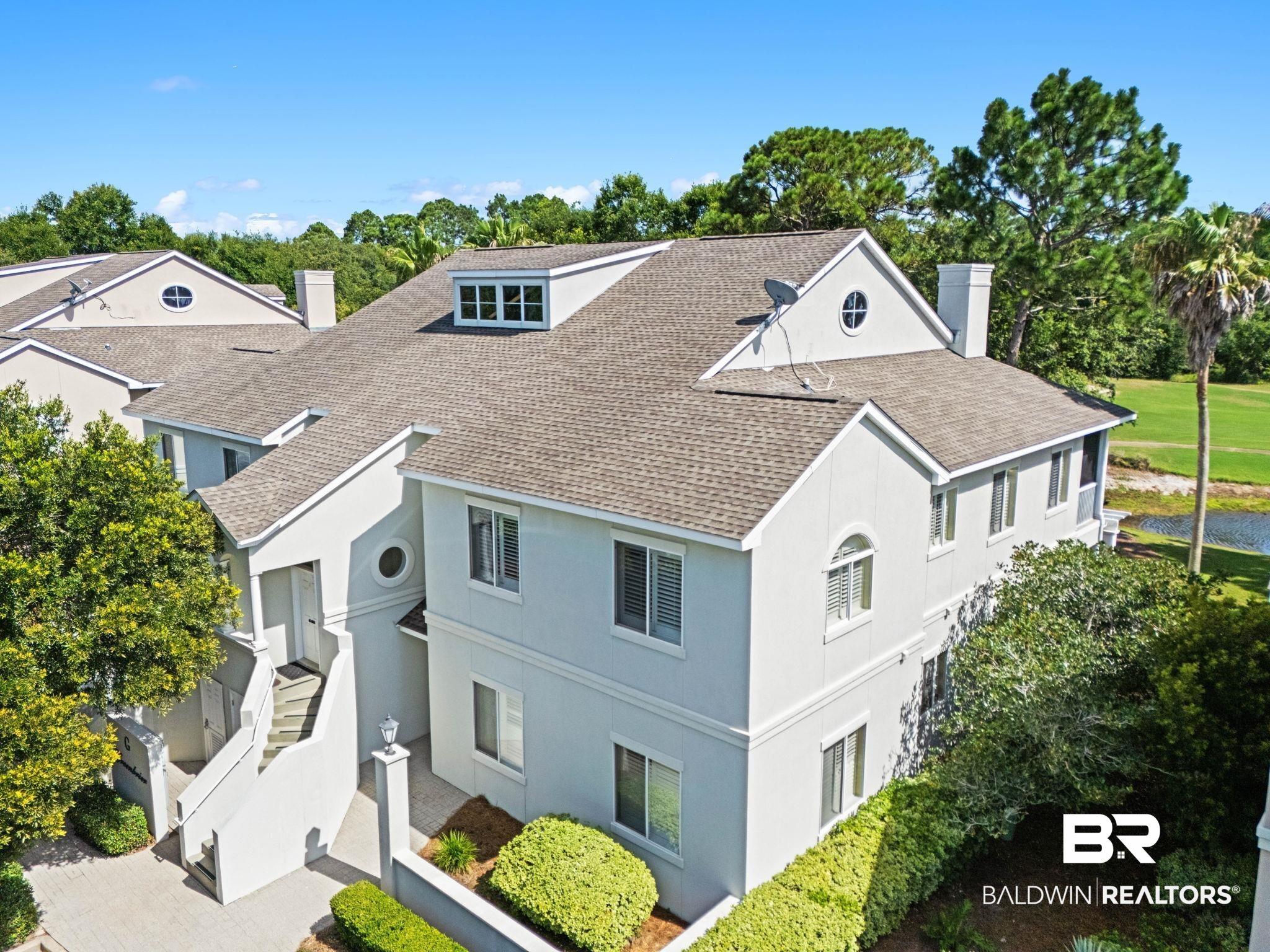 Image 4: Multi-level property featuring a light-toned exterior, gabled rooflines, and multiple windows