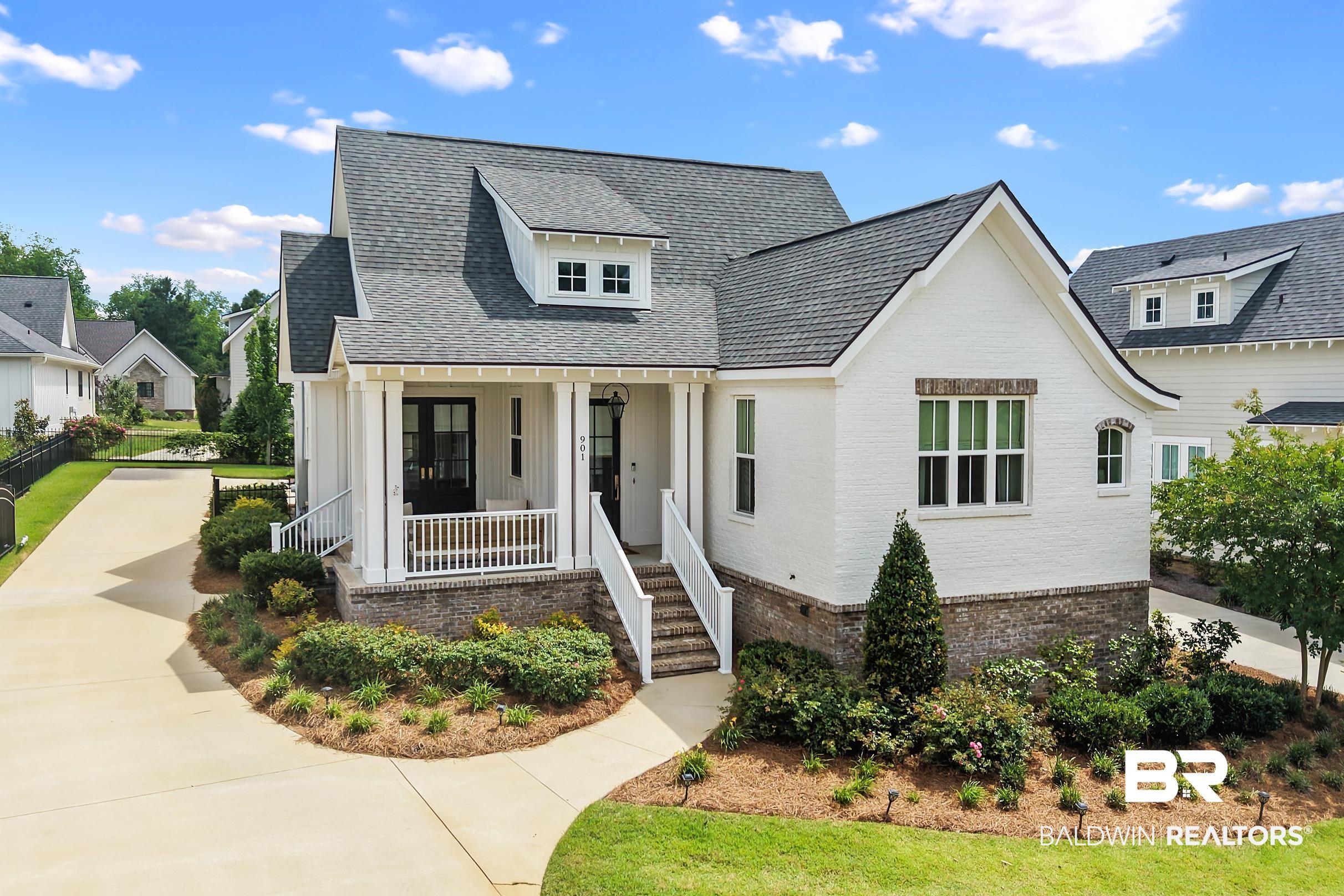 Image 1: White brick exterior with a dark shingle roof, featuring a front porch with white columns and railings